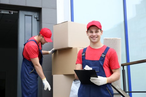 Professional movers carrying furniture through a flat staircase